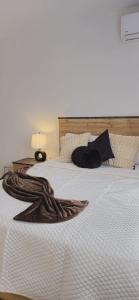a bedroom with a white bed with a blanket on it at D'Ponke Guest House in Cayey
