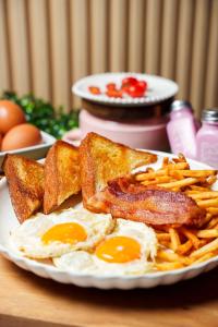 a plate of breakfast food with eggs and french fries at D'Ponke Guest House in Cayey