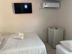 a room with a bed and a tv on the wall at Pousada Orienttal in Santarém +1 photo