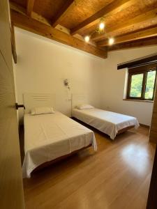 two beds in a room with wooden ceilings at Casa CABAÑA in Riaño