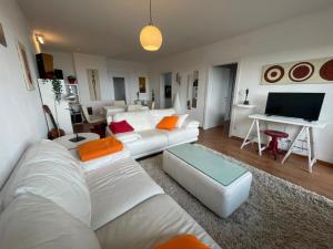 a living room with white furniture and a flat screen tv at Fernblick Appartement Simonhöhe in Zirkitz
