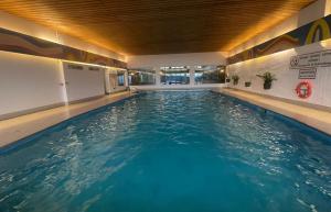 a swimming pool with blue water in a building at Fernblick Appartement Simonhöhe in Zirkitz