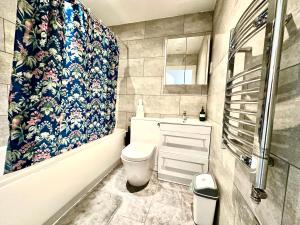a bathroom with a toilet and a sink and a shower at Stay in Stratford in London
