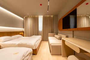 a hotel room with two beds and a couch at Hotel Berfin in Vlorë