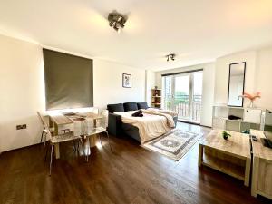 a living room with a bed and a large window at Stay in Stratford in London