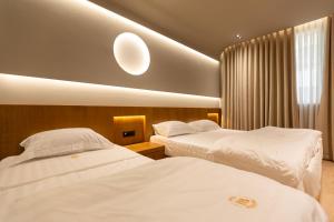 two beds in a hotel room with white sheets at Hotel Berfin in Vlorë