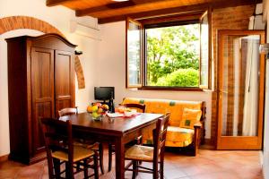 a dining room with a table and a couch at Appartamenti Il Granaio in Marina di Grosseto