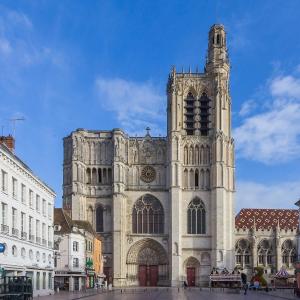 a large cathedral with a tower on a city street at Lion Or - Downtown - Sens in Sens