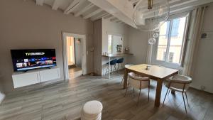 a living room with a dining table and a tv at Lion Or - Downtown - Sens in Sens