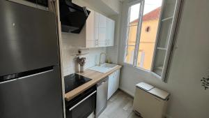 a small kitchen with a sink and a refrigerator at Lion Or - Downtown - Sens in Sens