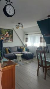 a living room with a couch and a clock on the wall at Kunst und Meer in Varel