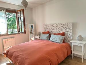 a bedroom with a large bed with orange sheets and pillows at BIOTY CHILL & SPA in Le Blanc-Mesnil +47 photos