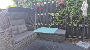 a wicker chair and a table next to a fence at Apartment am Park - Erica in Schneverdingen +2 photos