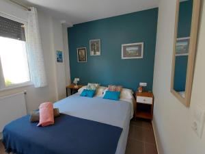 two beds in a bedroom with blue walls at Al Eu in Ribeira