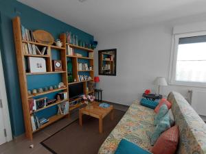 a living room with a couch and a book shelf at Al Eu in Ribeira +1 photo