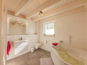 a white bathroom with a tub and a toilet at Villa Milla - Nordhorn in Nordhorn
