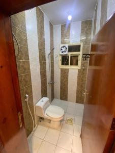 a small bathroom with a toilet and a window at نزل بسمة الأبداع in Abha
