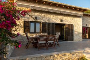 a patio with chairs and a table in front of a building at Celeste Syvota in Syvota