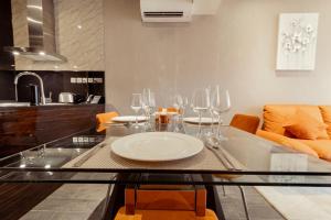 a dining room with a glass table with wine glasses at The Vynyard, Accra in Accra +26 photos
