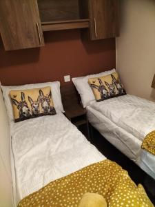 a room with two beds with pillows on them at Seaside Stay in Camber