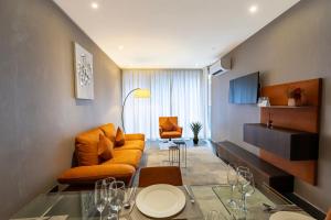 a living room with an orange couch and a table at The Vynyard, Accra in Accra