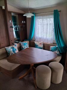 a living room with a wooden table and a couch at Seaside Stay in Camber +1 photo