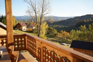ein Holzbalkon mit Blick auf die Berge in der Unterkunft Vatra Chalet in Măgura