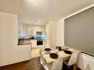 a kitchen with a table and chairs in a room at Stay in Stratford in London