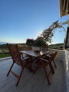 a wooden table and two chairs on a deck at Celeste Syvota in Syvota +24 photos