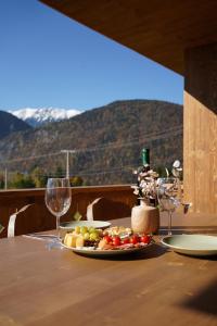 ein Tisch mit einem Teller Essen und Weingläsern in der Unterkunft Vatra Chalet in Măgura