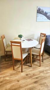 a dining room table with two chairs and a white table at Fonyódi Süllő Garzon in Fonyód