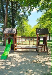 a playground with a green slide and a bench at Fonyódi Süllő Garzon in Fonyód