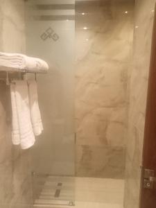 a glass shower in a bathroom with white towels at Boutique Hotel El Mesaadia in Cairo +39 photos