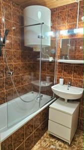 a bathroom with a shower and a sink and a tub at Fonyódi Süllő Garzon in Fonyód