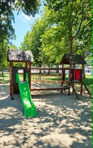 a playground with a green slide and a bench at Fonyódi Süllő Garzon in Fonyód +35 photos