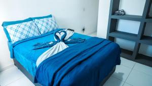 a bedroom with a blue bed with a blue comforter at Smart Flat Apart in Mogi das Cruzes