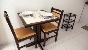 a table with two plates and two chairs and a table at Smart Flat Apart in Mogi das Cruzes