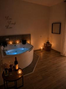 a bathroom with a tub and a table with candles at Dudi Jolie Maison - Jacuzzi in Lezzeno +15 photos