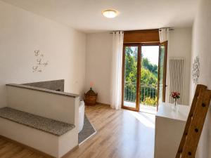 a living room with a staircase and a sliding glass door at Dudi Jolie Maison - Jacuzzi in Lezzeno