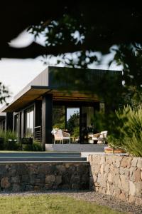 a modern house with a stone wall at Scorzamara Country Lodges - Retreats with Private Pool or Jacuzzi in Carlentini