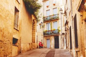 a person walking down a street in an alley at Hôtel D'Aragon - Place de la Comédie - in Montpellier