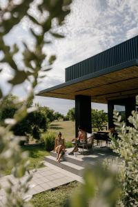 two men sitting on a patio of a house at Scorzamara Country Lodges - Retreats with Private Pool or Jacuzzi in Carlentini