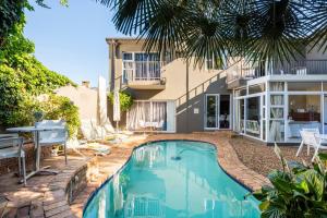 a swimming pool in front of a house at Your homely experience in Paarl