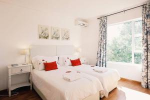 a white bedroom with two beds and a window at Your homely experience in Paarl +75 photos
