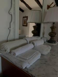 a pile of towels sitting on a table in front of a mirror at Il Carpino - Dimora Fresca e parcheggio in Carpineto Romano +50 photos