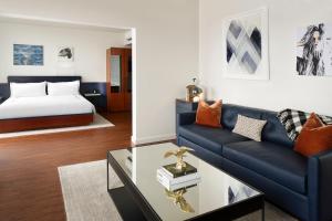 a living room with a blue couch and a bed at Thompson Seattle, by Hyatt in Seattle +18 photos