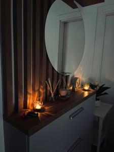 a dresser with a mirror and candles on it at Porodična oaza Vrnjačka Banja in Vrnjačka Banja +15 photos