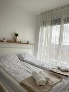 a bed with towels on it with a window at Porodična oaza Vrnjačka Banja in Vrnjačka Banja