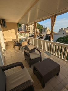 a balcony with chairs and tables and a view of a city at Apartmani Dubravka in Rafailovici