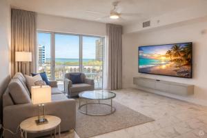 a living room with a couch and a tv at CW Hotel in Clearwater Beach